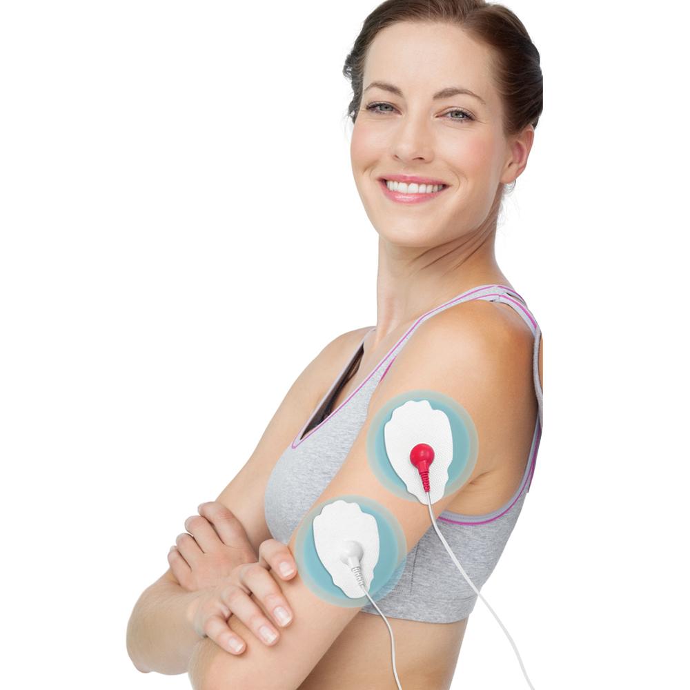 woman smiling during the use of a tens machine, with the picture showing a clear positioning of a electrode on her arm